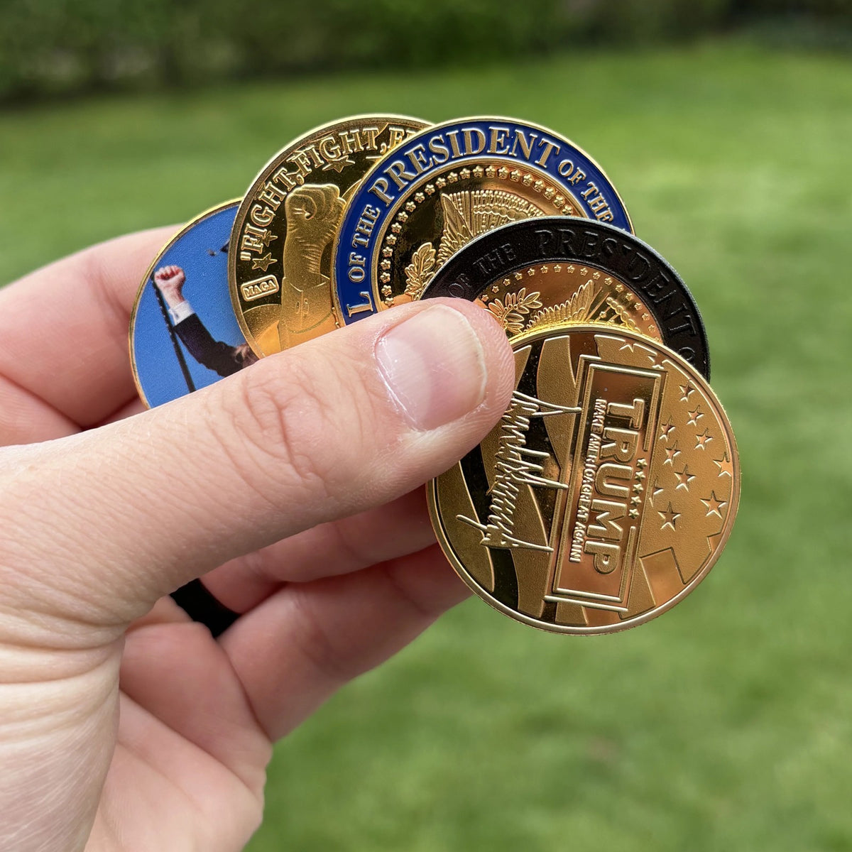 Trump Fight Fight Fight Coin held with other coins from our Trump line (sold separately), outdoors