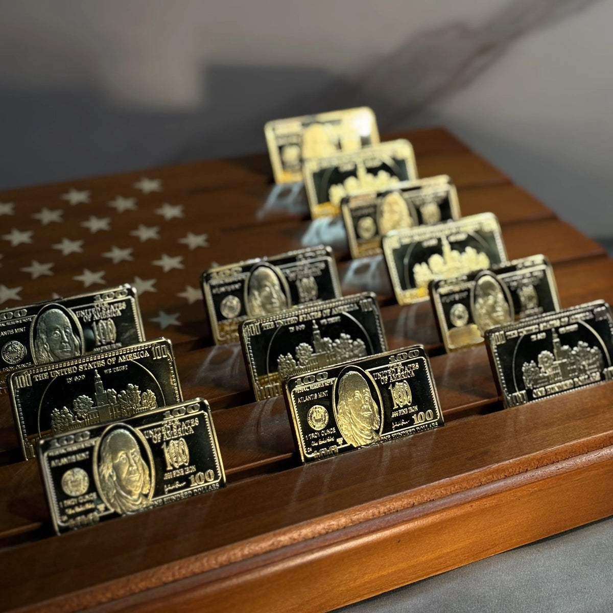 Rows of Ben Franklin $100 gold-plated bars on a wooden star display tray