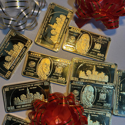Ben Franklin $100 gold-plated bars scattered among gift bows and ribbon