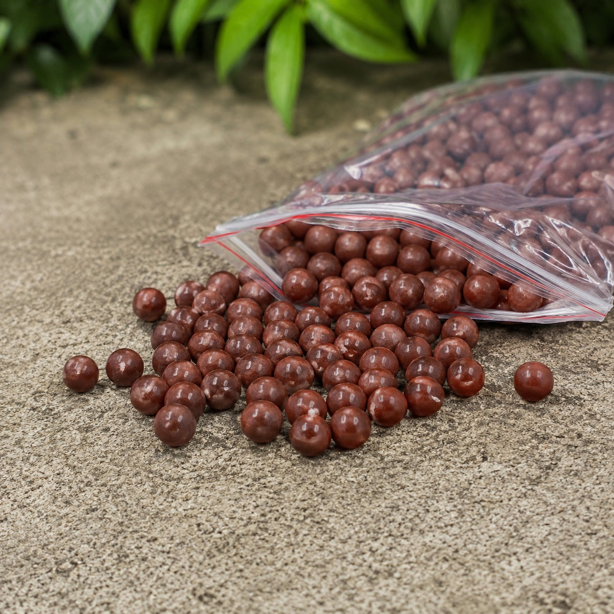 Bag of clay slingshot beads spilling onto a stone ledge