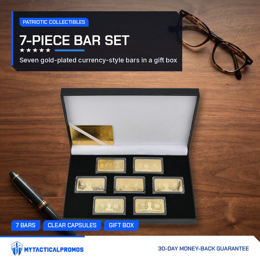 7-piece gold-plated currency bar set in its open presentation box on a wooden desk