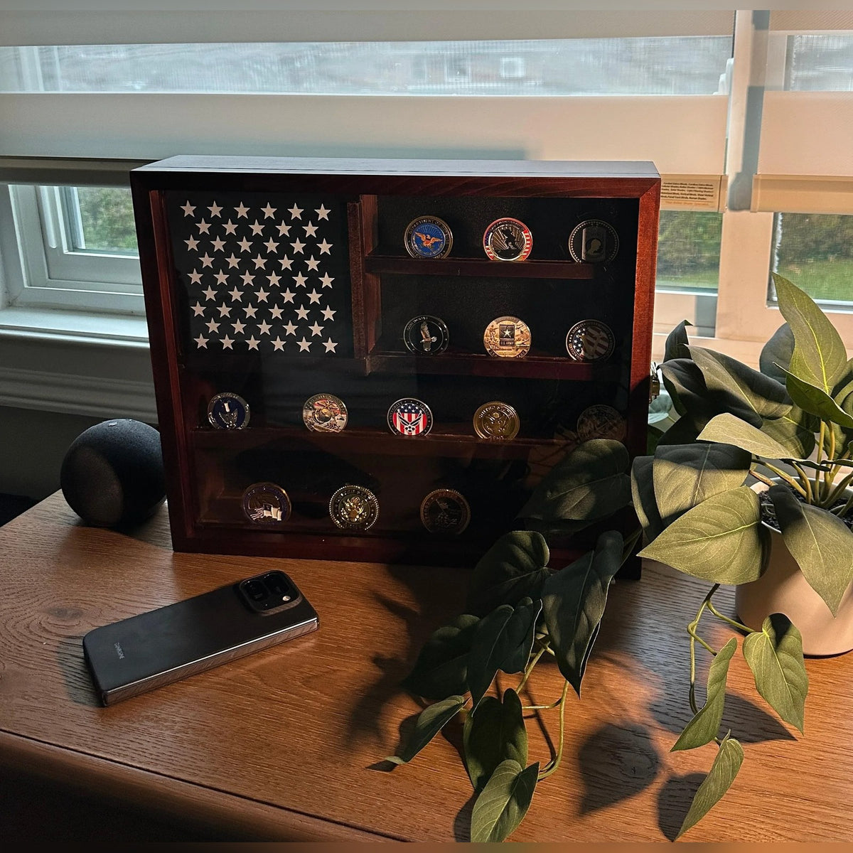 American Flag Challenge Coin Display Case on a desk by a window