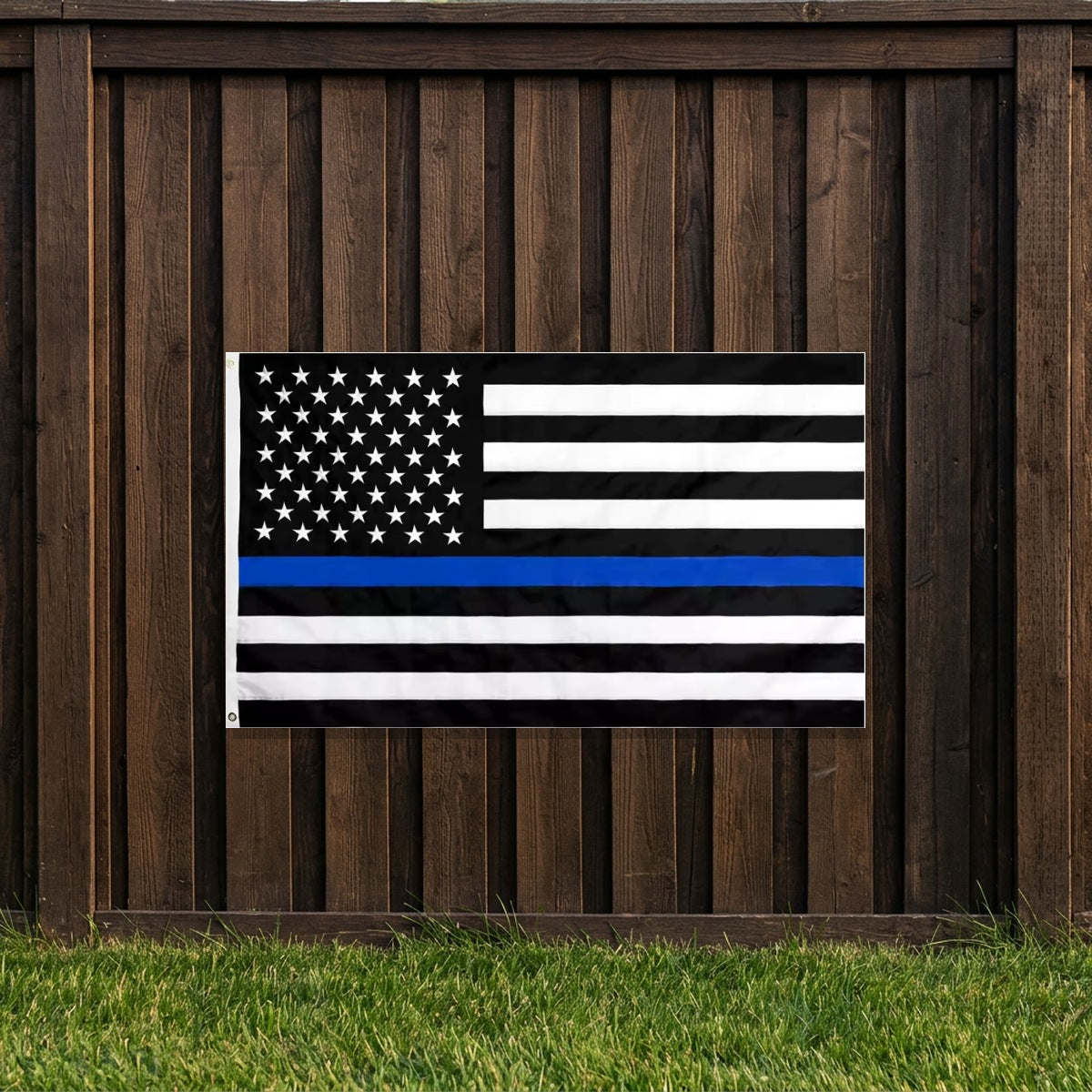 Thin Blue Line Flag hung on a dark wooden backyard fence