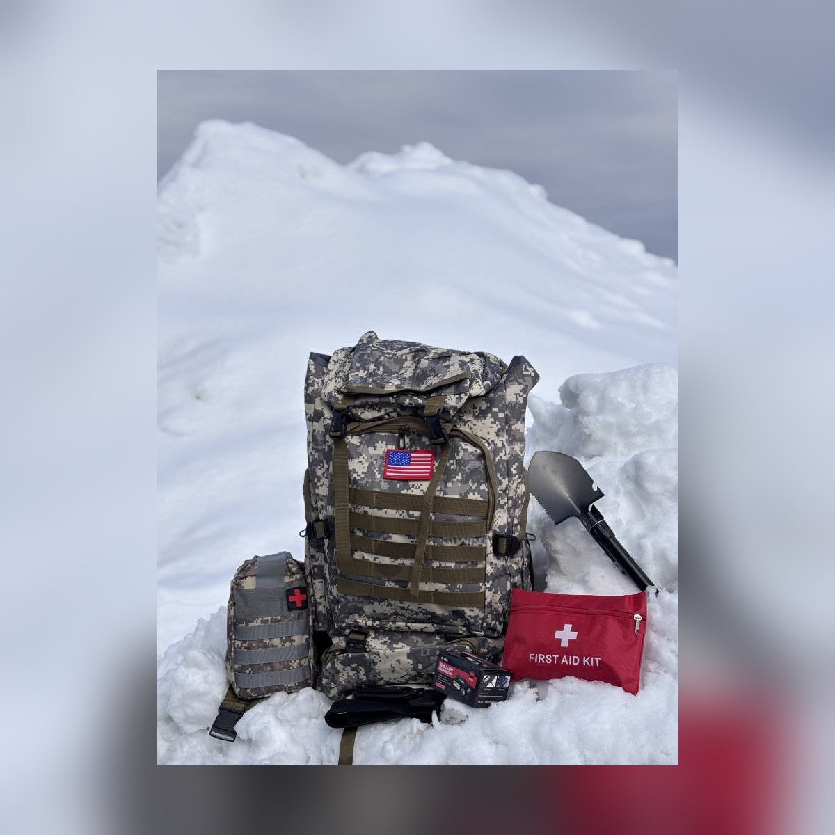 Bugout Backpack with first aid kits and shovel set in a snowbank