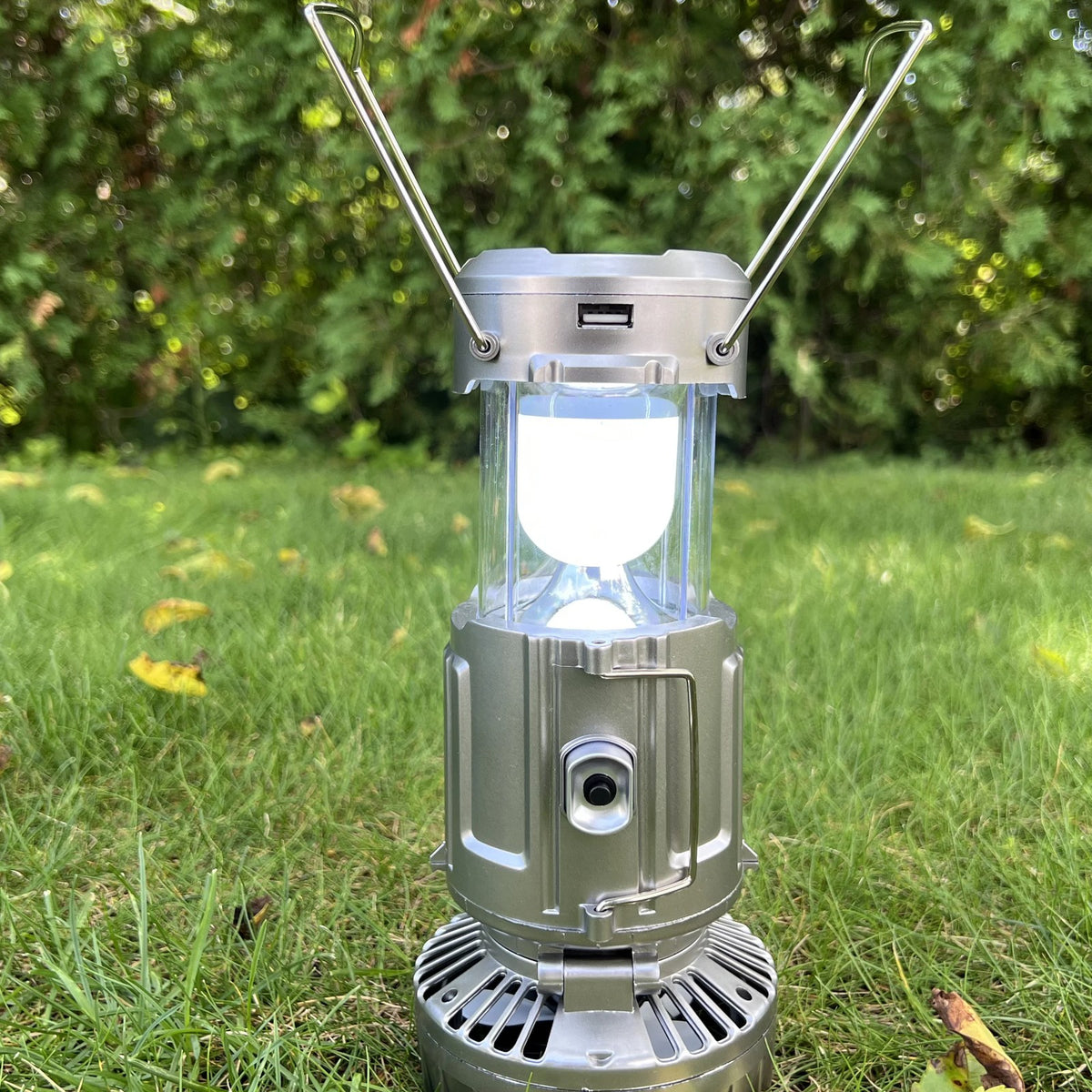 Solar Camping Lantern lit on a lawn with its handles raised