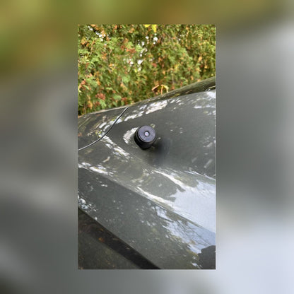 Circle Mini Spy Camera stuck magnetically to a car trunk lid outdoors