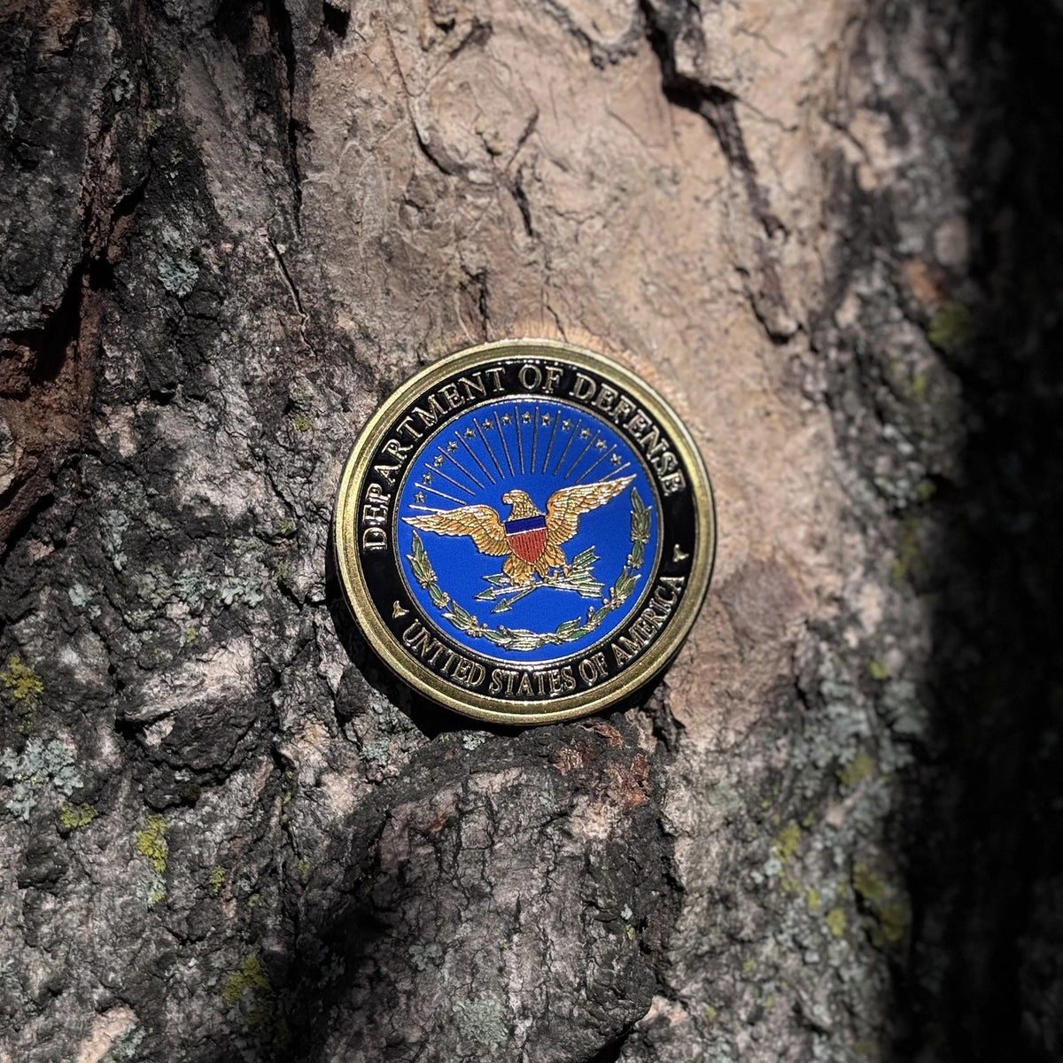 Defense Tribute Coin eagle side set against tree bark