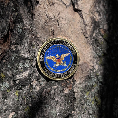 Defense Tribute Coin eagle side set against tree bark