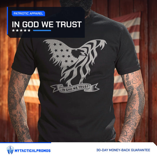 Eagle In God We Trust T-Shirt worn by a man in front of a red barn wall with an American flag