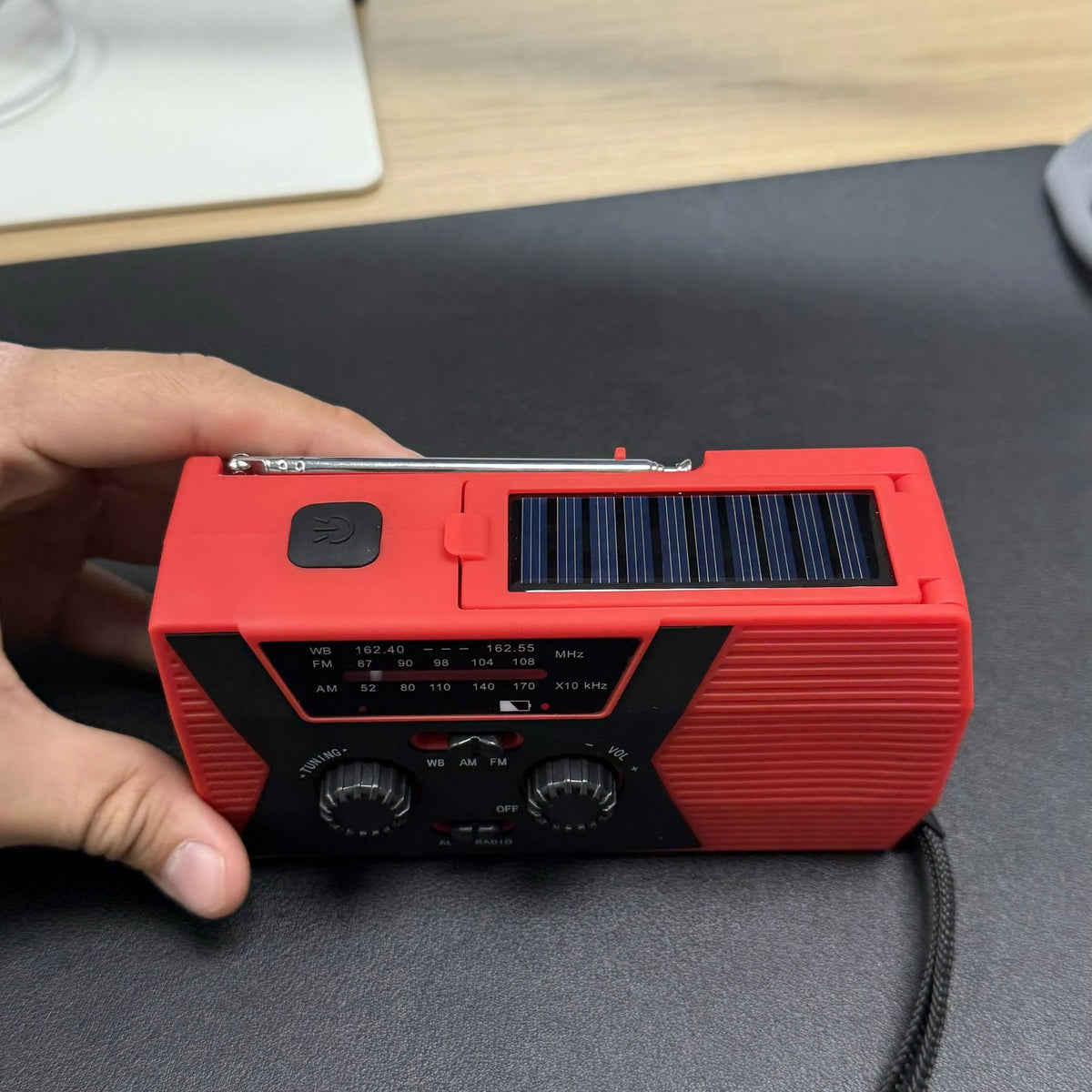 Emergency Radio held in hand showing the solar panel on top