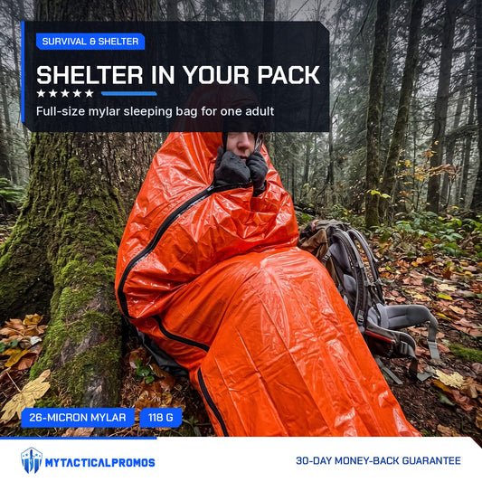 Hiker wrapped in the orange Emergency Sleeping Bag against a tree in the forest