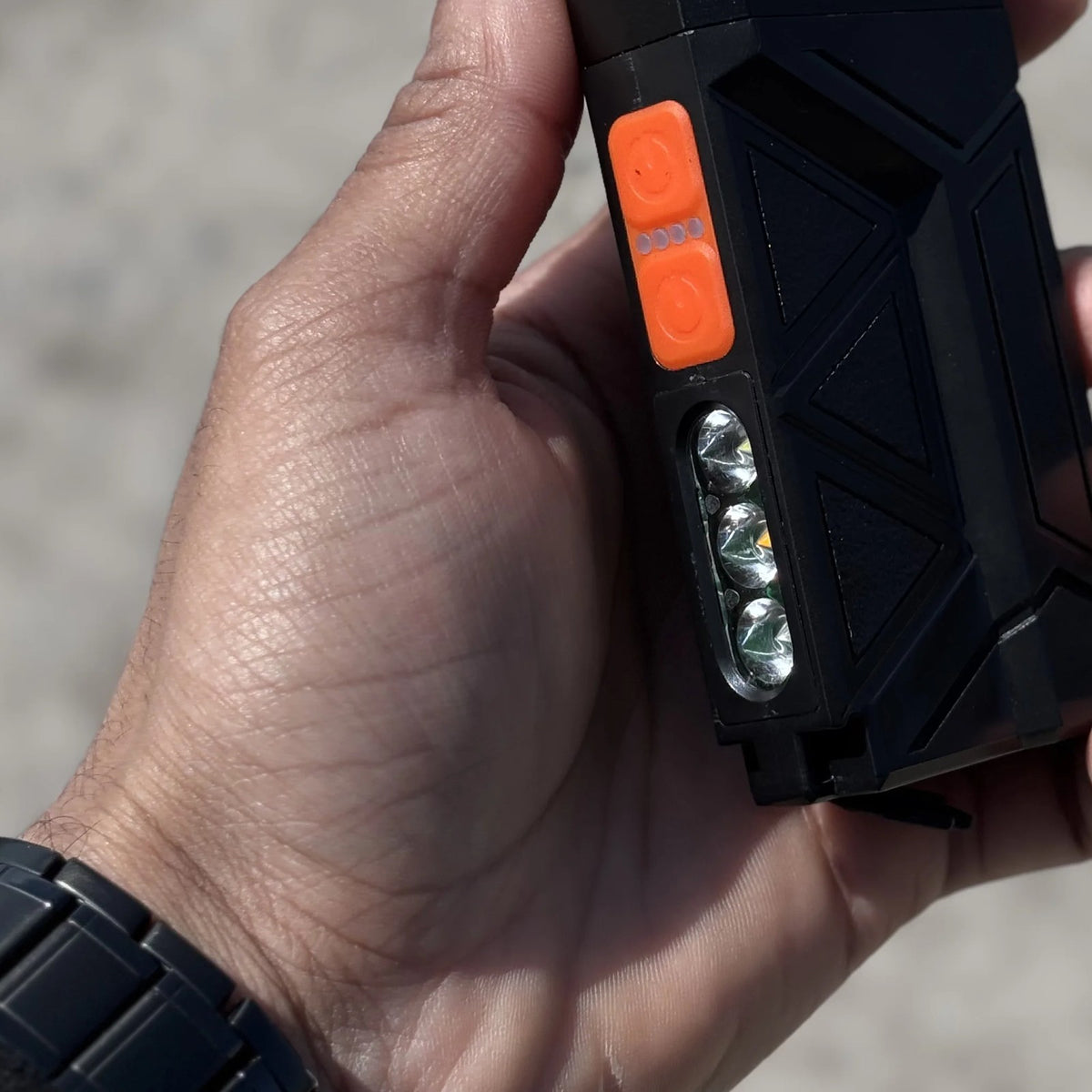 Flat Flashlight in hand outdoors, showing its flat profile and side LEDs