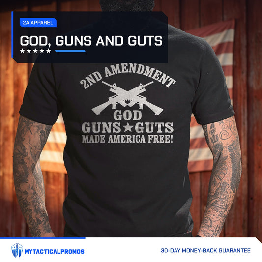 God, Guns and Guts T-Shirt worn by a man in front of a red barn wall with an American flag