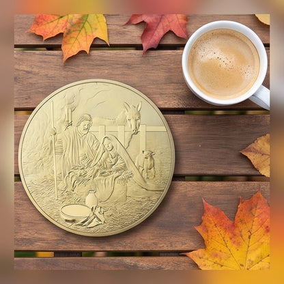 Jesus Commemorative Coin nativity side on a wood table with autumn leaves and coffee