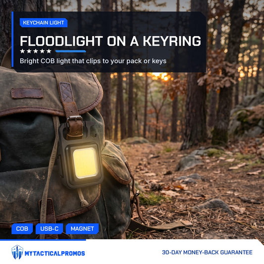 Keychain Light lit and clipped to a canvas backpack in a forest at sunset