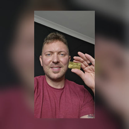 Smiling man holding up the Last Supper gold-plated bar