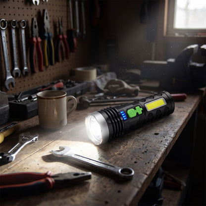 LED Flashlight lit on a garage workbench beside a wrench and mug