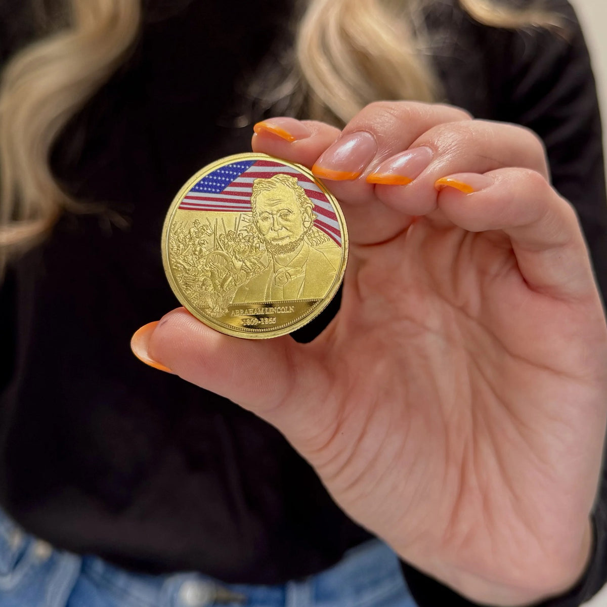 Abraham Lincoln Gold-Plated Coin held between fingers to show its size