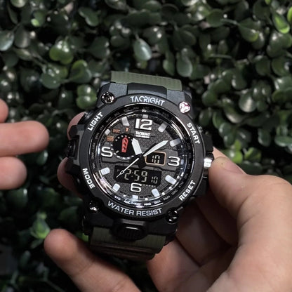 Military Watch held in hand outdoors against green hedge