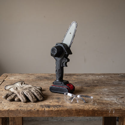 Mini Cordless Chainsaw standing on a wooden workbench with gloves and safety glasses