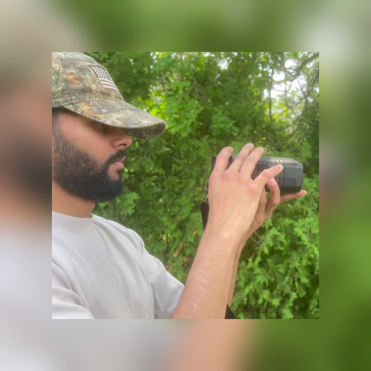 Man in a camo cap looking through the Night Vision Binoculars