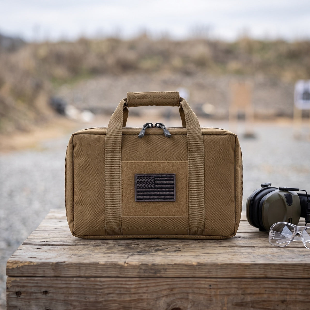 Pistol Gun Bag on a wooden bench at an outdoor range beside ear protection and safety glasses
