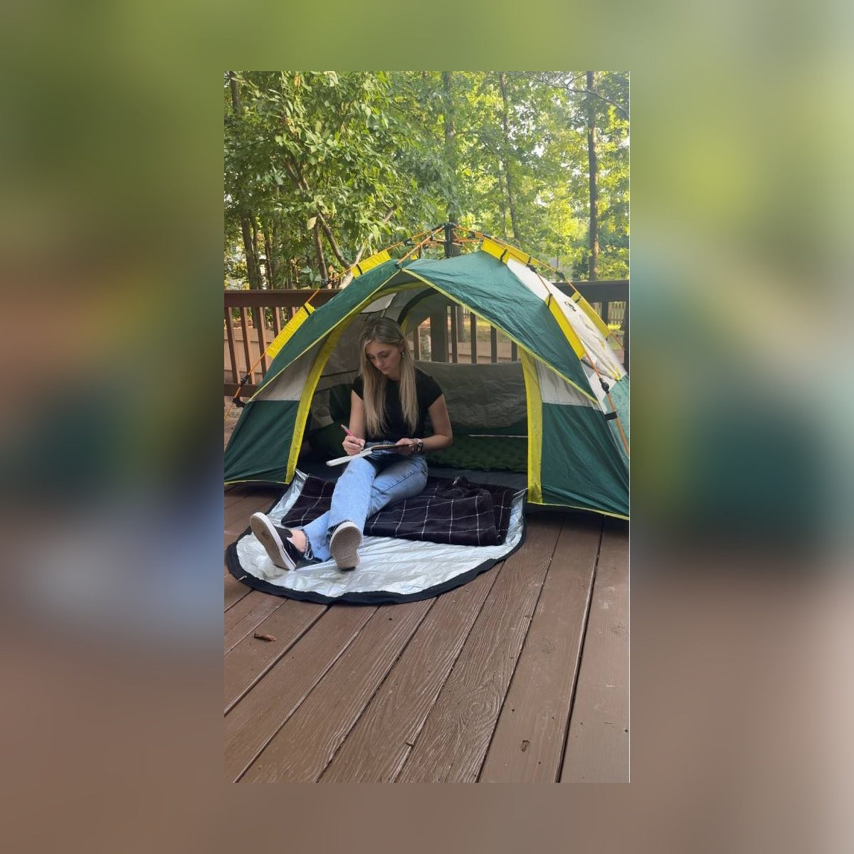 Woman reading inside the Quick Popup Tent set up on a backyard deck