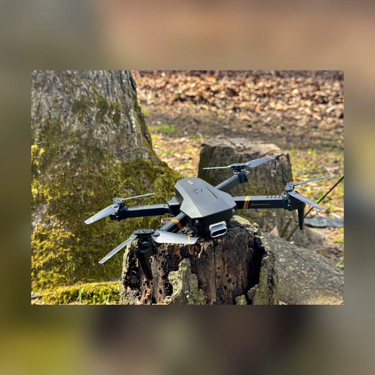 RC Drone with arms unfolded, resting on a tree stump outdoors