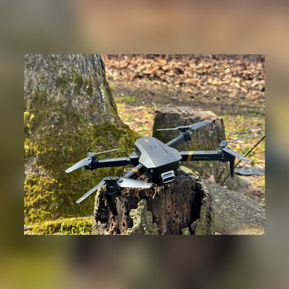 RC Drone with arms unfolded, resting on a tree stump outdoors