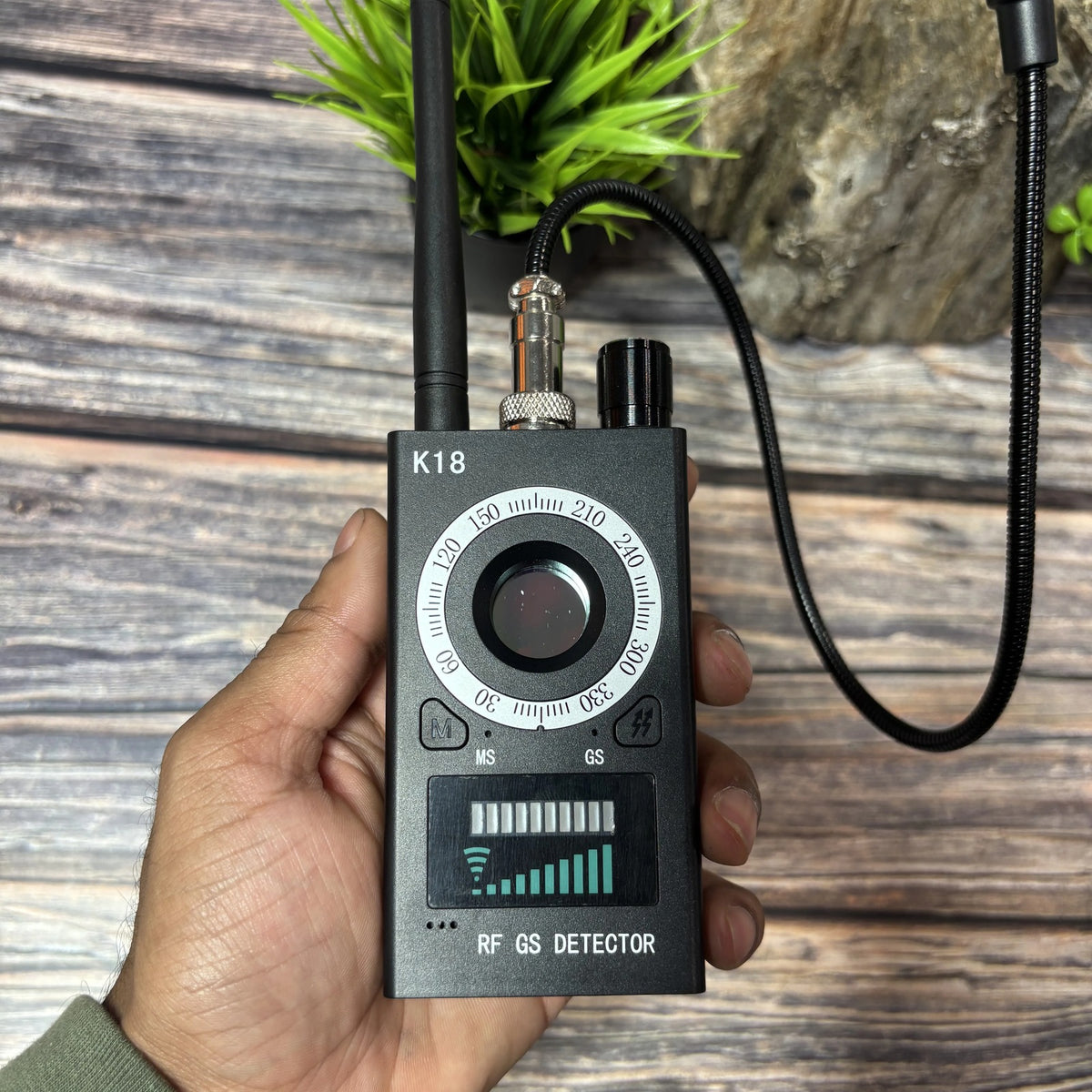 Spy Bug Detector held in hand with antenna and gooseneck probe attached