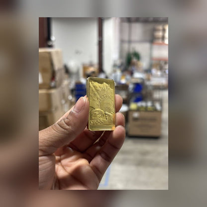 Statue of Liberty gold-plated bar held between fingers for size