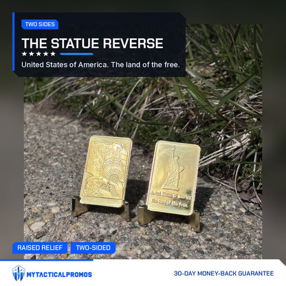 Two Statue of Liberty gold-plated bars on stands outdoors showing the eagle front and the Statue reverse