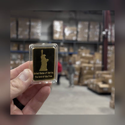 Statue of Liberty gold-plated bar reverse in a clear capsule held in hand