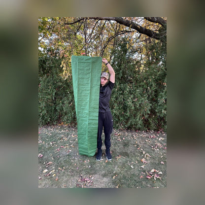 Man holding the Survival Mattress upright to show its full length against his height