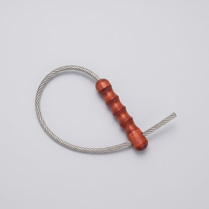 Tactical Whip braided steel cable and wooden handle on a plain background