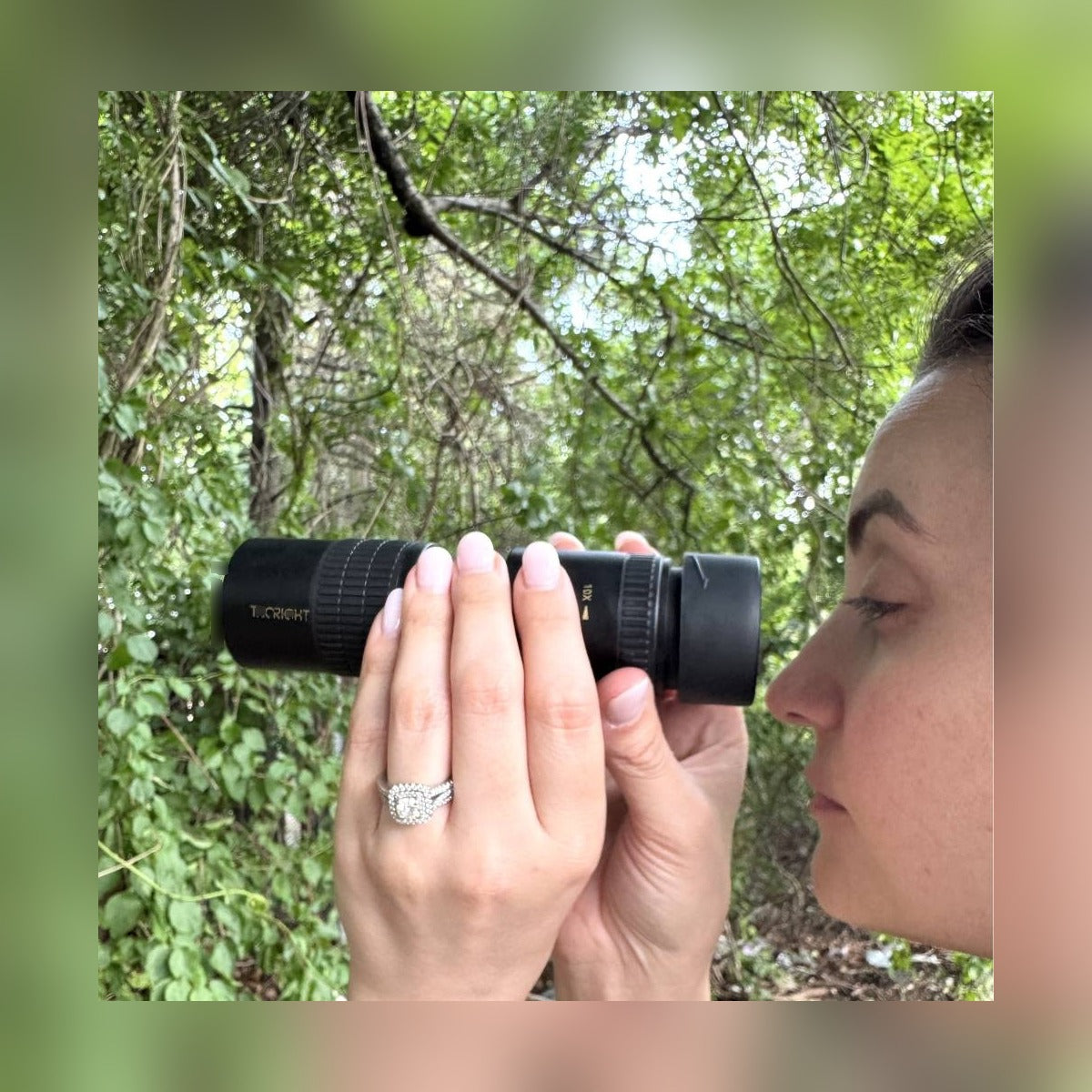 Woman looking through the Zoom Monocular Telescope held in one hand