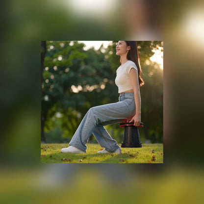 Woman resting on the Telescoping Camp Stool in a sunny park