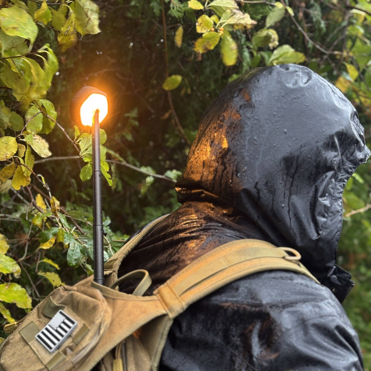 Telescoping Camping Lantern extended and lit, carried in a backpack in the rain