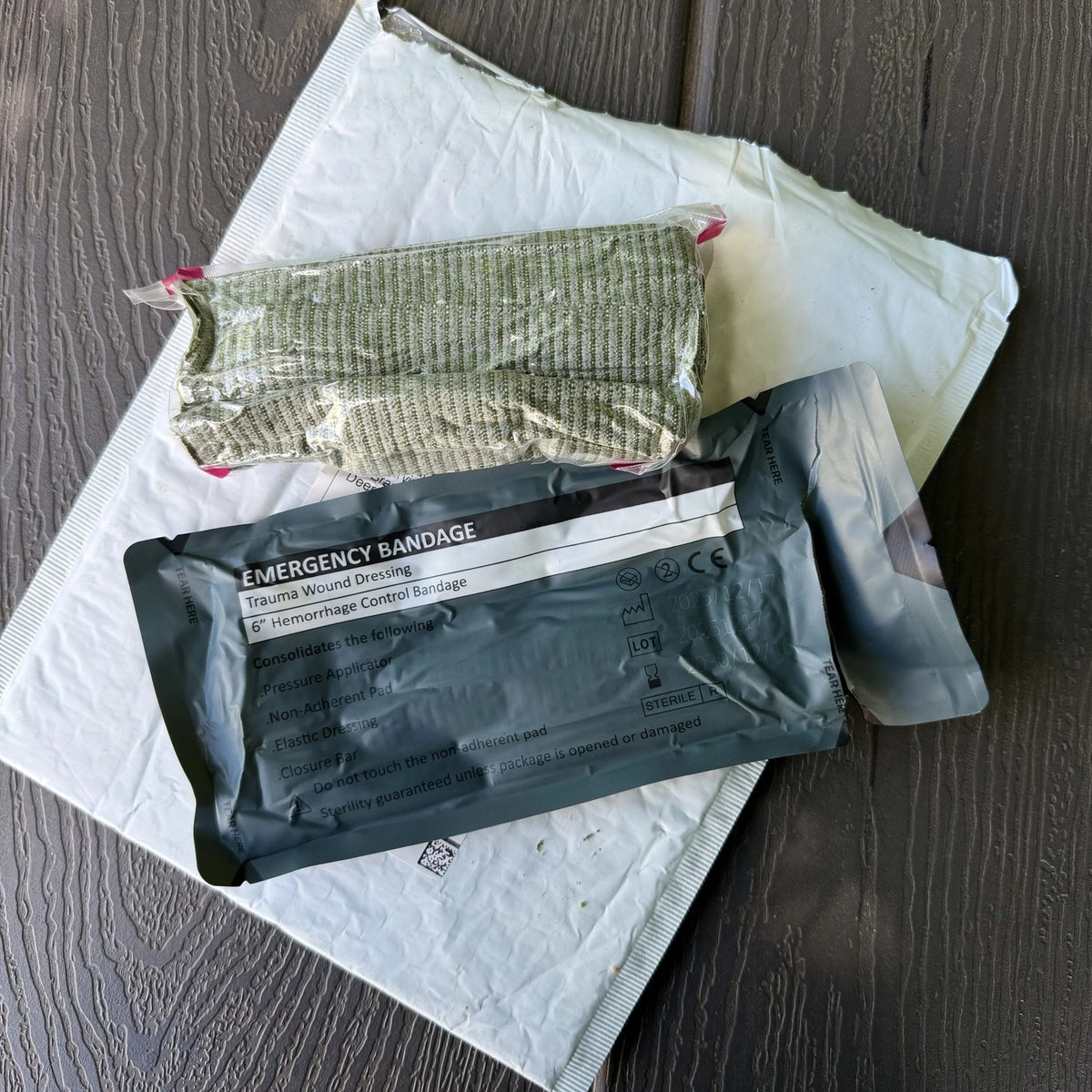 Trauma Bandage vacuum-sealed pack beside the rolled olive elastic wrap