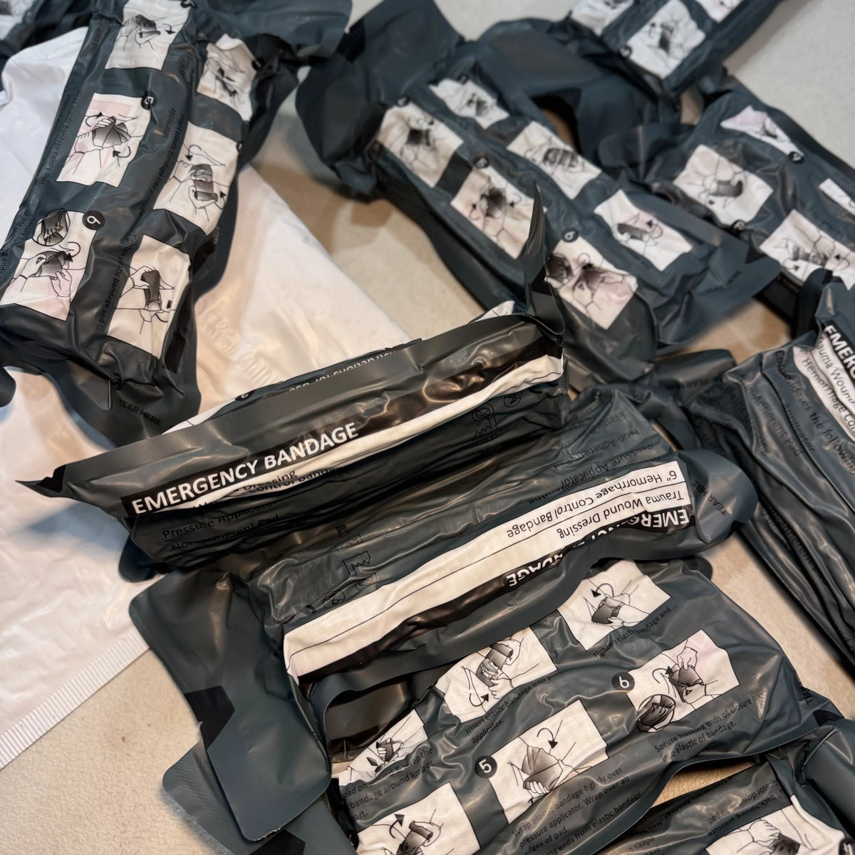 Several Trauma Bandage packs, labeled Emergency Bandage, for stocking kits