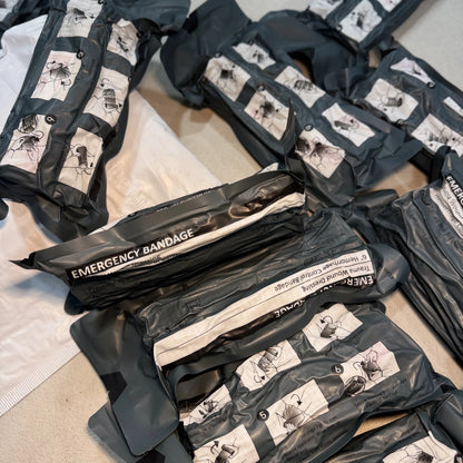 Several Trauma Bandage packs, labeled Emergency Bandage, for stocking kits