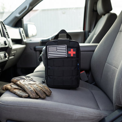 Trauma First Aid Kit on the passenger seat of a pickup truck next to work gloves
