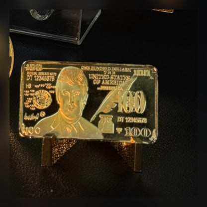 Trump $100 portrait gold-plated bar on a small stand on a desk