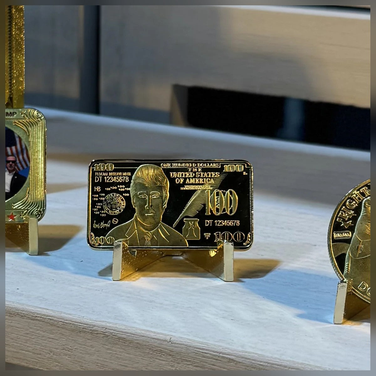 Trump $100 portrait gold-plated bar standing on a white shelf