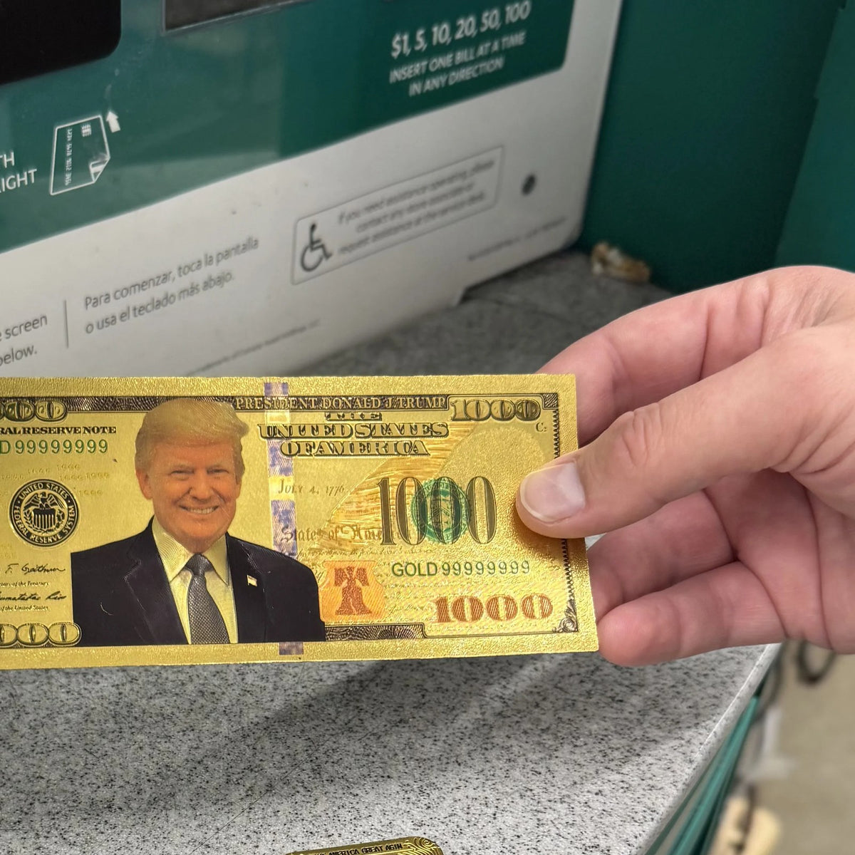 Trump $1000 gold foil novelty bill held in one hand for size