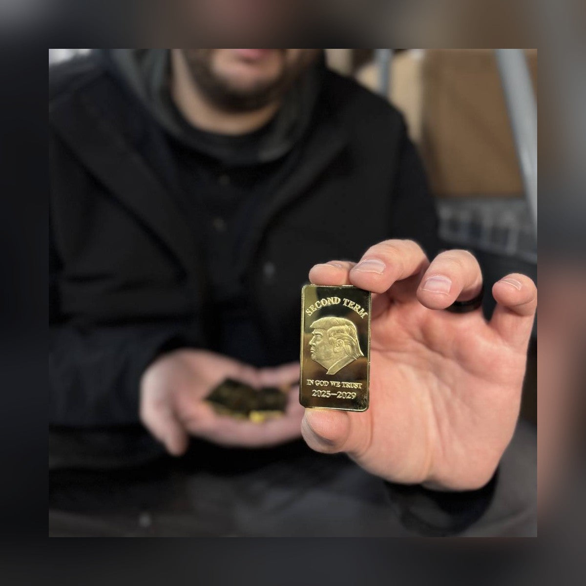 Trump Second Term gold-plated bar held between fingers for size