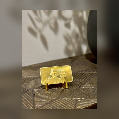 Trump July 13 commemorative gold-plated bar on a stand on a textured shelf