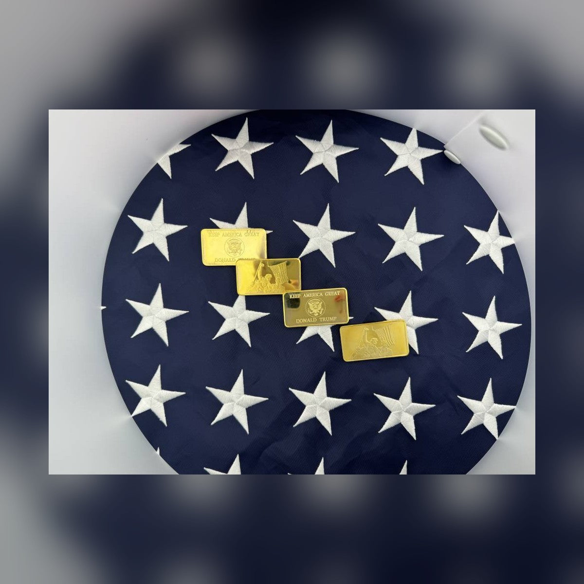 Trump July 13 commemorative gold-plated bars laid on an American flag