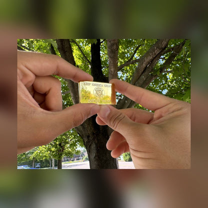 Keep America Great reverse of the Trump July 13 bar held between two hands outdoors