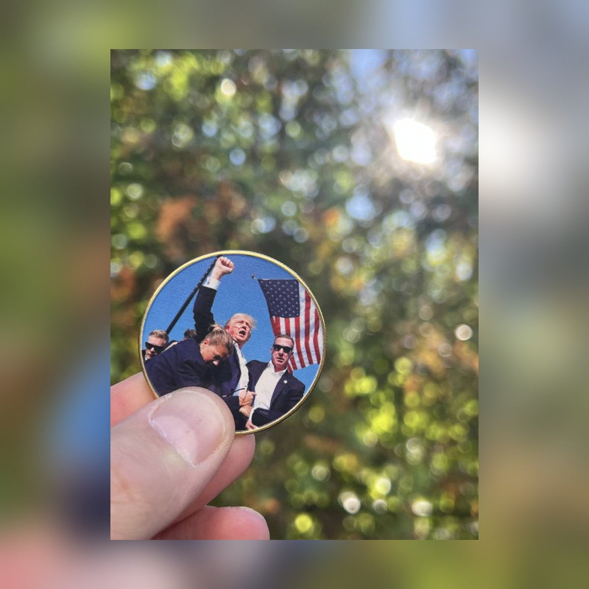 Trump July 13 Coin full-color side held up outdoors